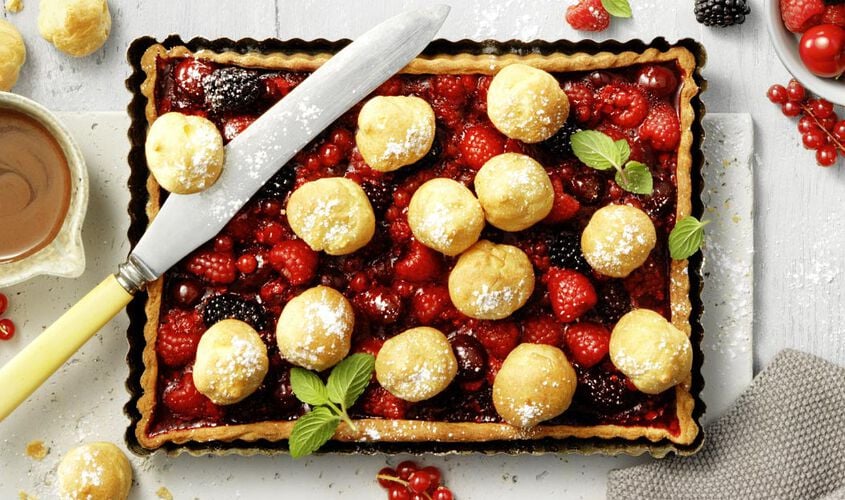 Tarte fruitée avec choux à la crème, baies et sauce au chocolat