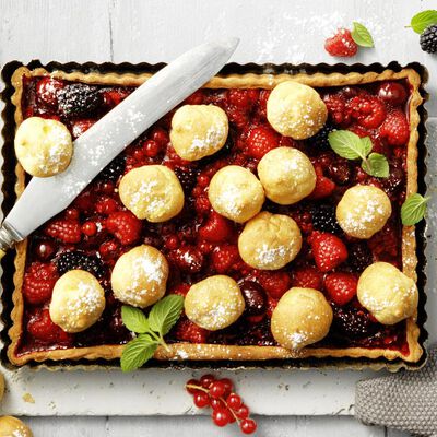 Crostata fruttata con mini bignè, frutti di bosco e salsa di cioccolato